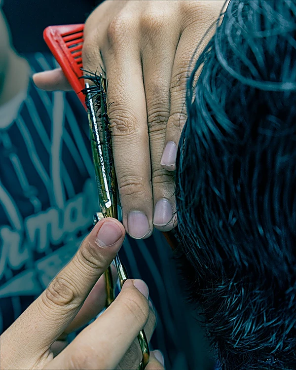 Peine rojo y herramienta de corte sobre el cabello, de cerca
